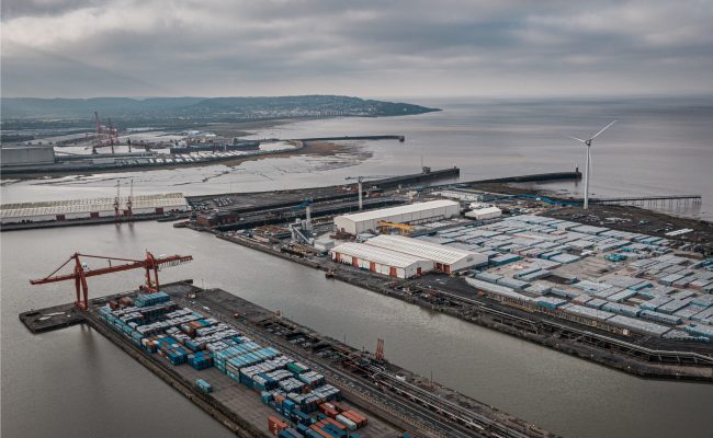 An aerial shot of industrial seaport under a cloudy sky